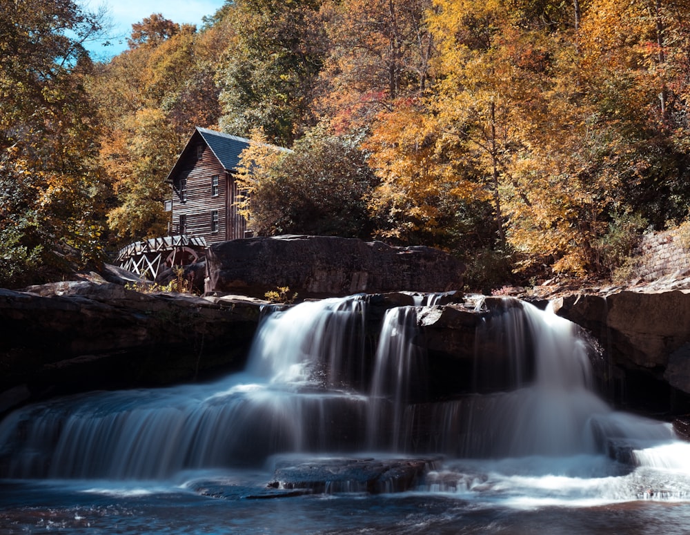 a waterfall with a water mill in the background