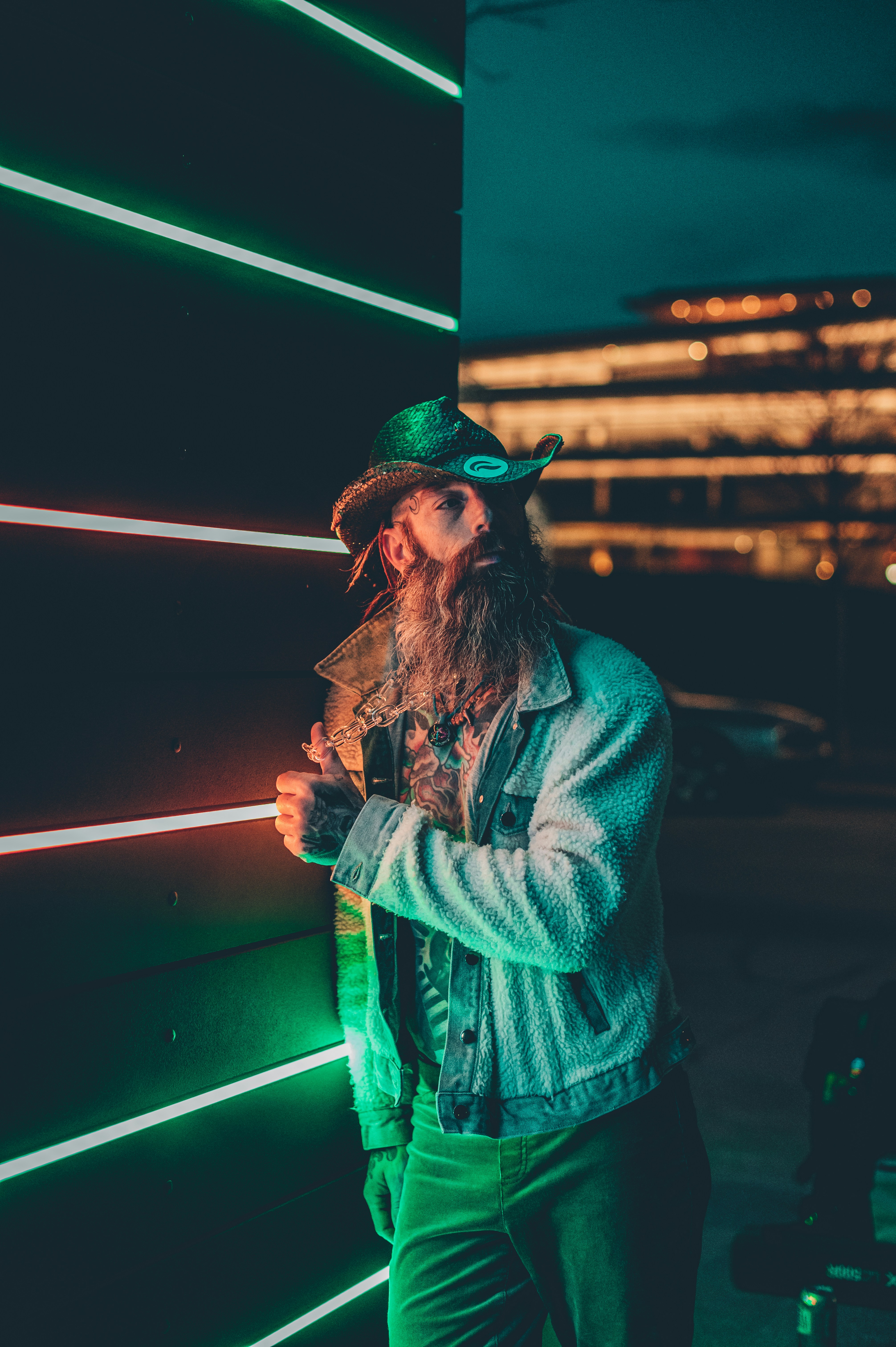 a man with a long beard wearing a green hat