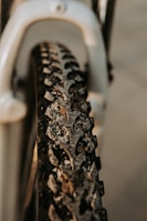Close-up of a muddy enduro bike tire spinning on a rocky path.