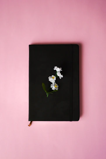 A modern pink and lilac notebook with floral accents, styled on a minimalist desk