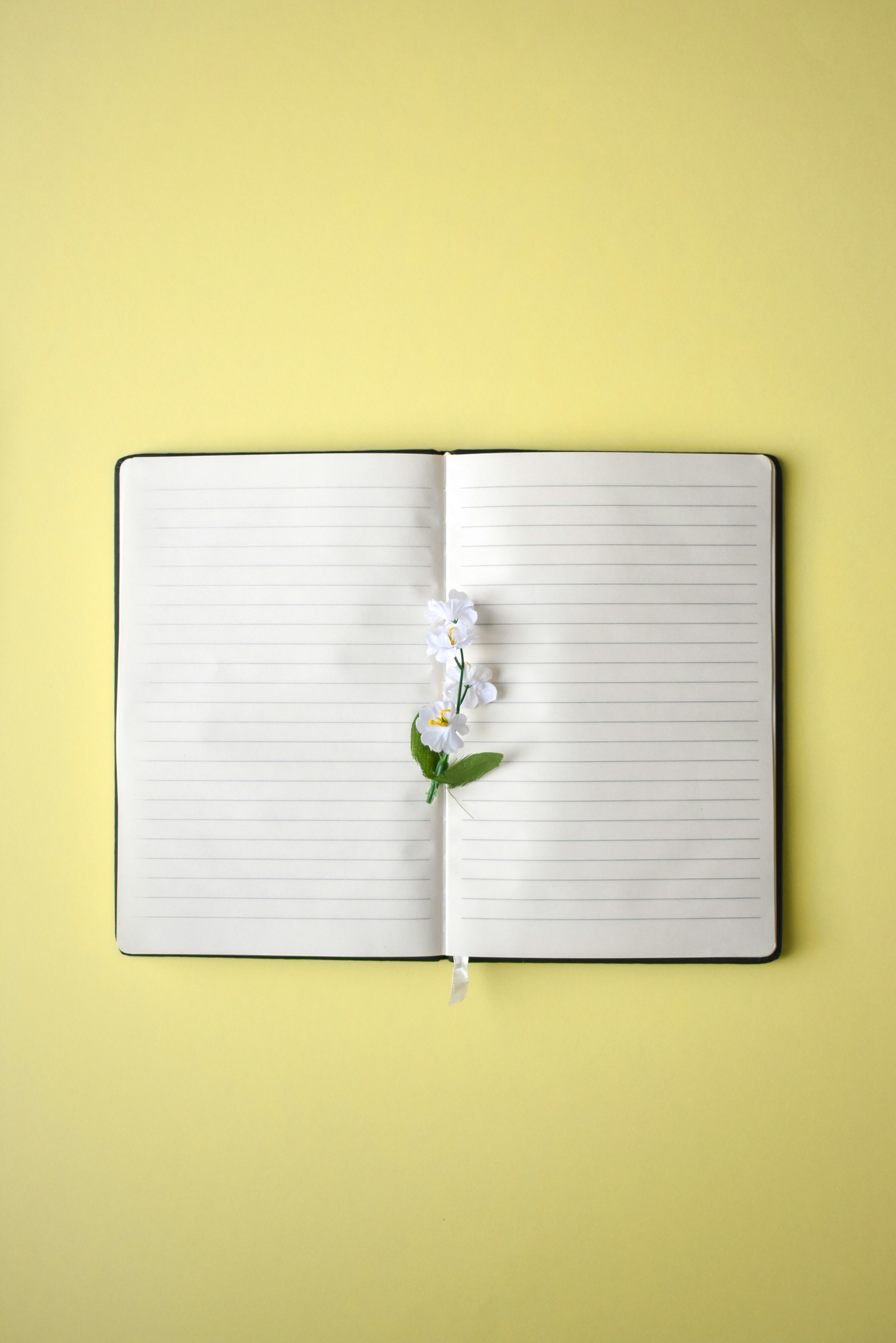 a notebook with a flower on top of it