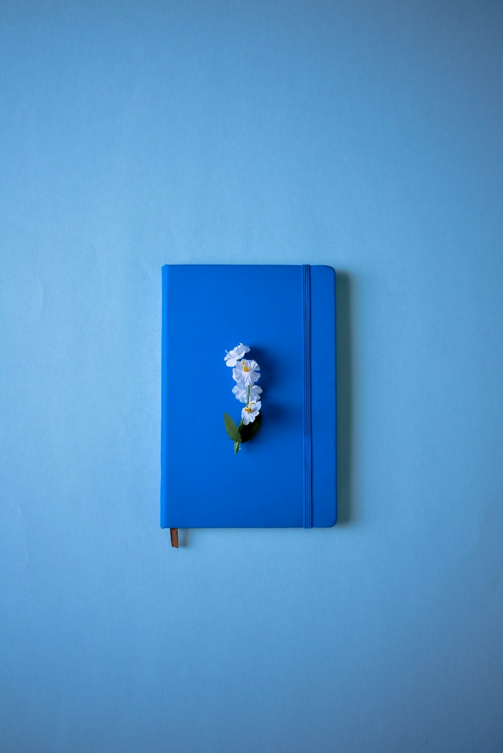a blue notebook with a flower on top of it