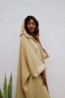 Model wearing a sleek, navy blue Daily Prayer hoodie standing in a sunlit garden, radiating calm and motivation.