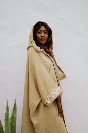 Model wearing a sleek, navy blue Daily Prayer hoodie standing in a sunlit garden, radiating calm and motivation.