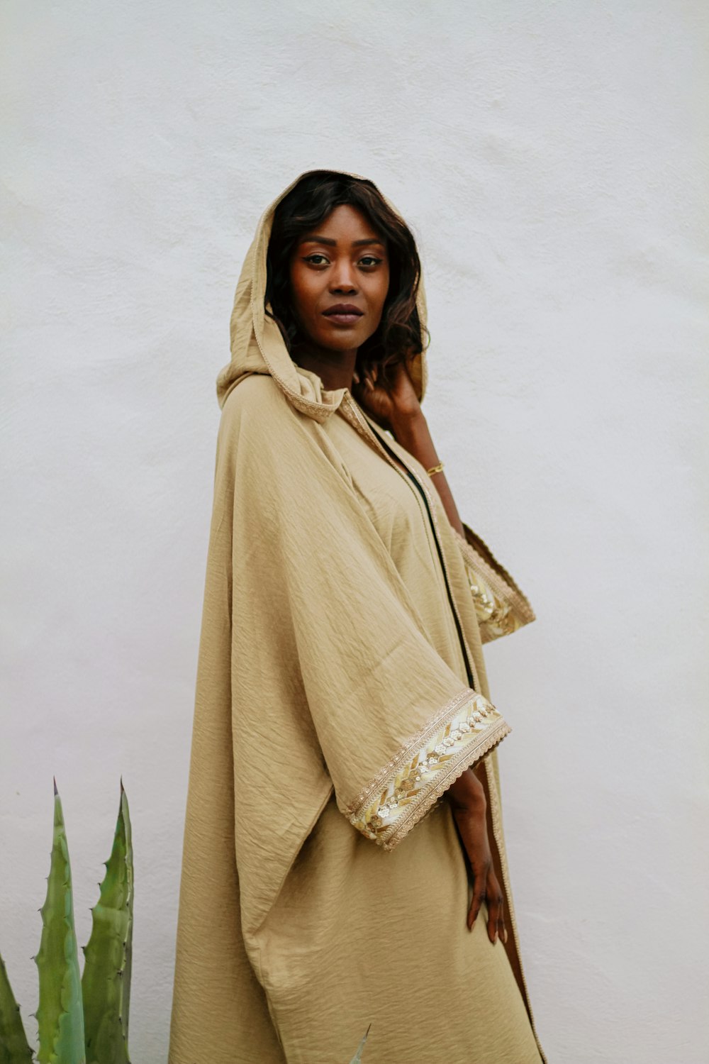 a woman standing in front of a white wall