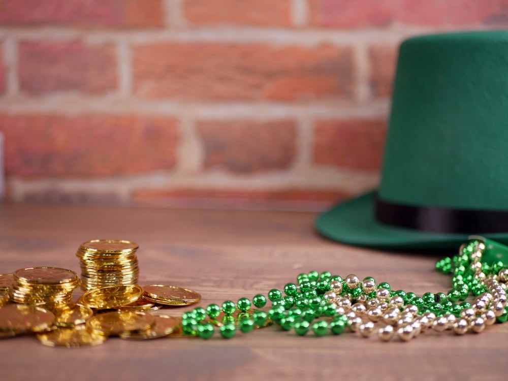 a green hat and some gold coins on a table