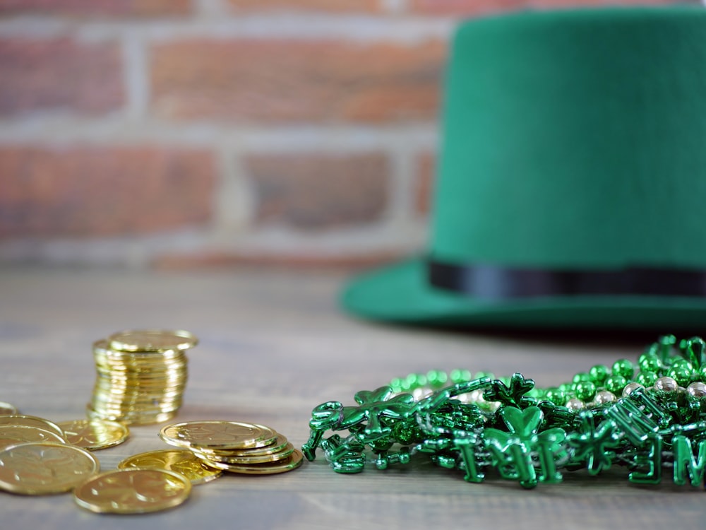 a green hat and some gold coins on a table