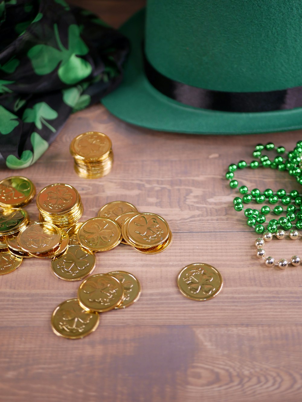 a green hat and some gold coins on a table