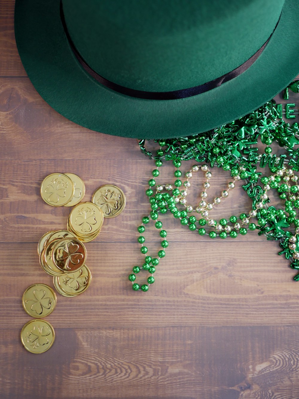 a green hat, beads, and a green hat on a wooden table