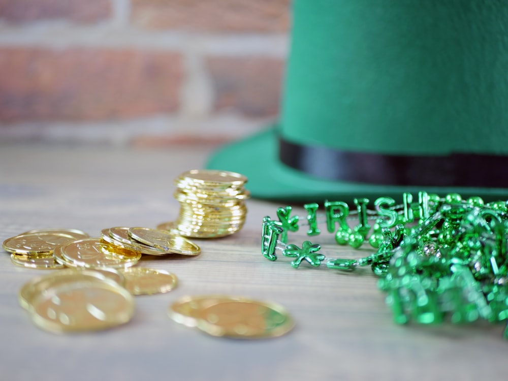 a green hat and some gold coins on a table