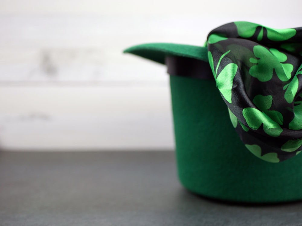 a green hat with a black and green flower on it