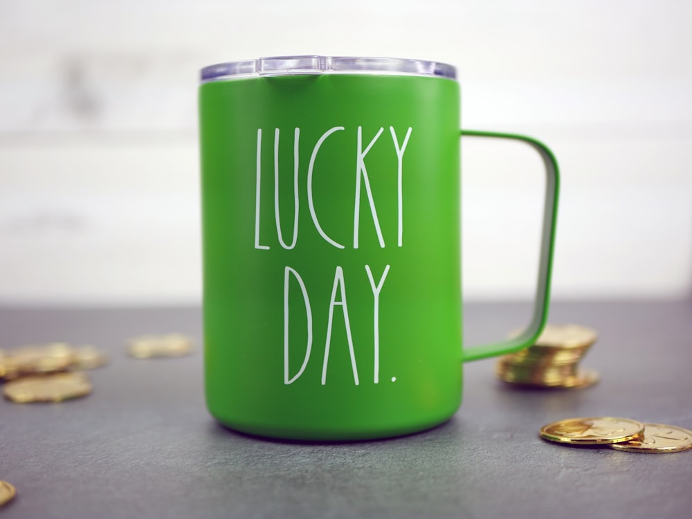 uma caneca de café verde com as palavras dia de sorte escritas nela
