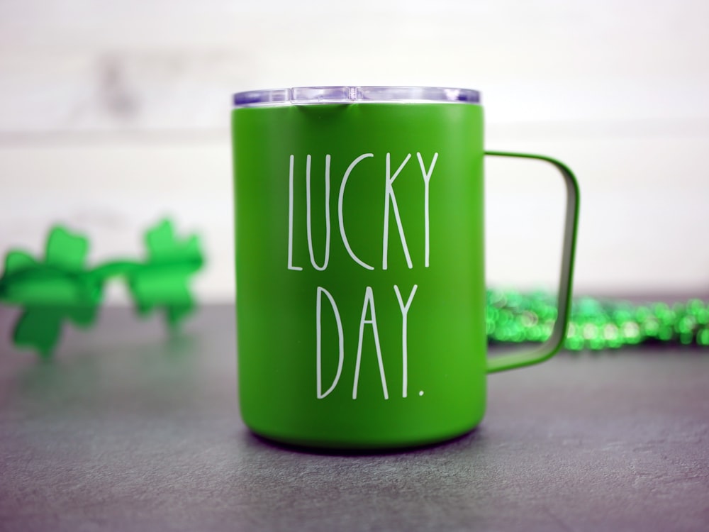 Una tazza di caffè verde con le parole Lucky Day scritte su di essa