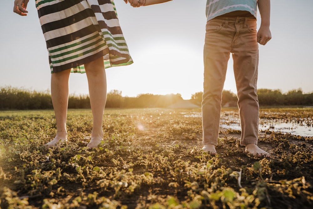 a man and a woman holding hands in a field