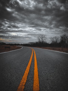 an empty road with two yellow lines in the middle of it