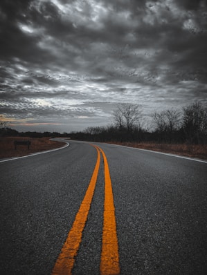 an empty road with two yellow lines in the middle of it