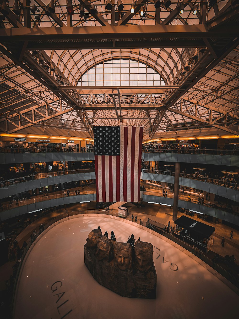 a large american flag hanging from the ceiling of a building