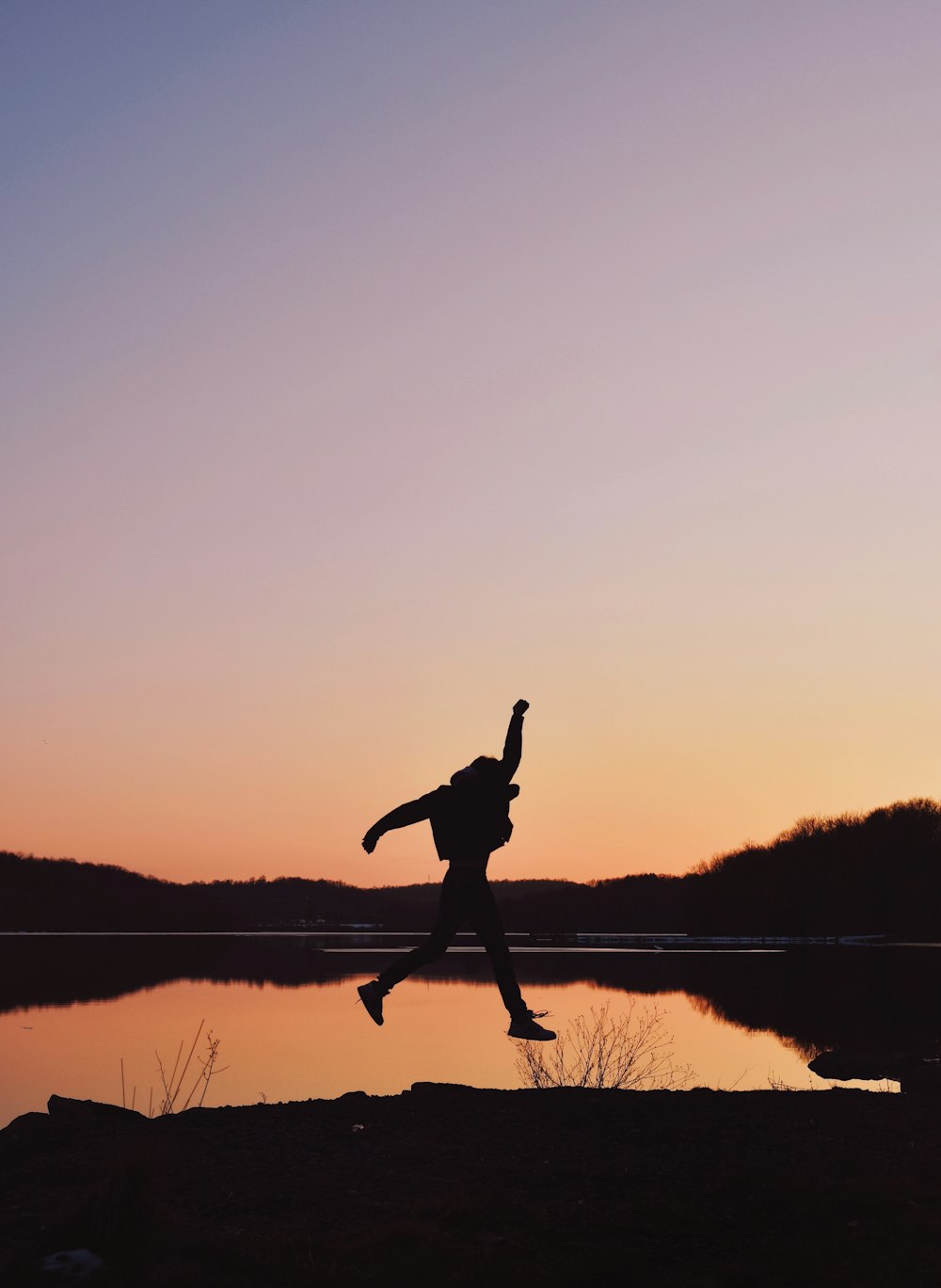 a person jumping in the air near a body of water