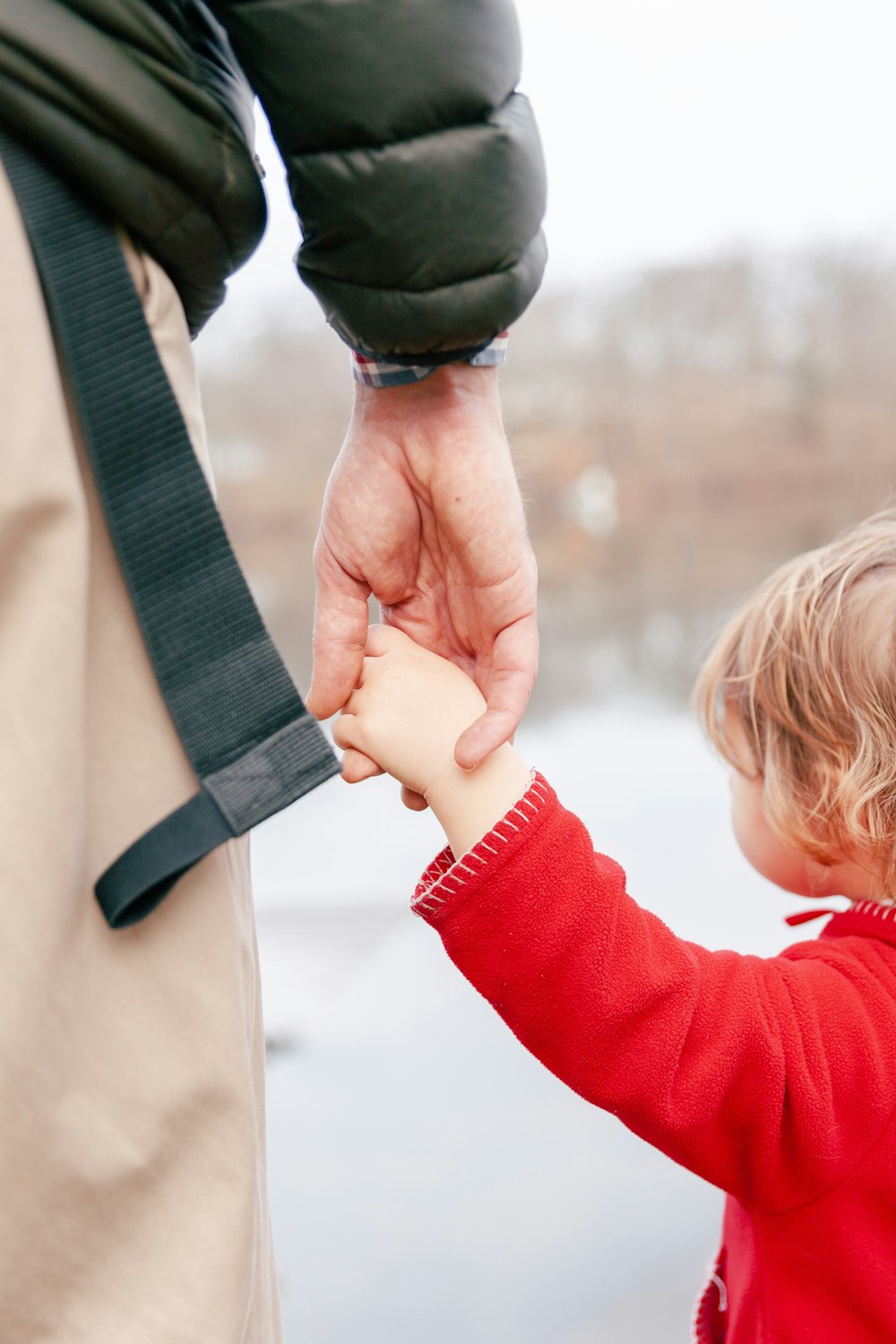 a man holding the hand of a small child