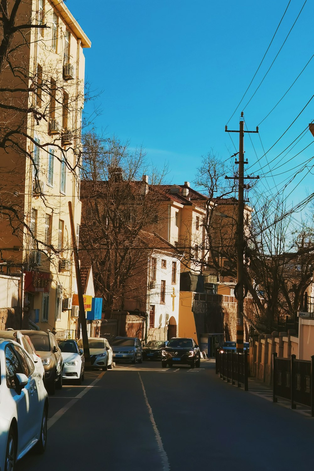 a street lined with parked cars next to tall buildings