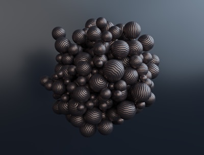An abstract cluster of numerous black spheres of varying sizes, each marked with thin, wavy white lines, arranged in a chaotic yet coherent three-dimensional formation against a gradient gray background.