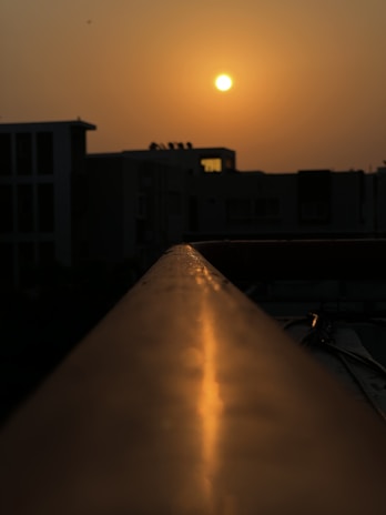A cinematic still of a sunset over a quiet cityscape, capturing warm golden hues and long shadows.