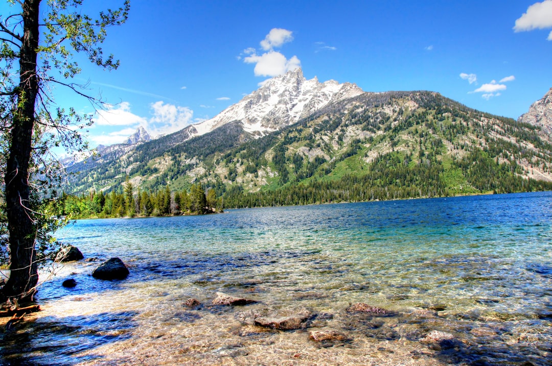 a lake with a mountain in the background, Jenny Lake at Grand Teton National Park - 1592</p></figure><p>Grand Teton National Park lies in Northwestern Wyoming about ten miles south of Yellowstone National Park.