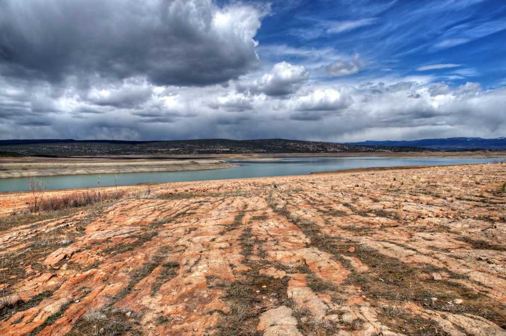 a wide open field with a body of water in the distance