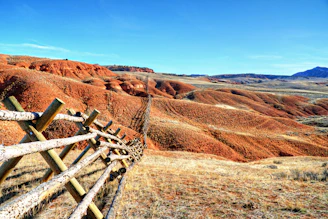 a wooden fence in the middle of a field