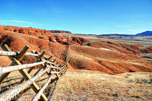 a wooden fence in the middle of a field