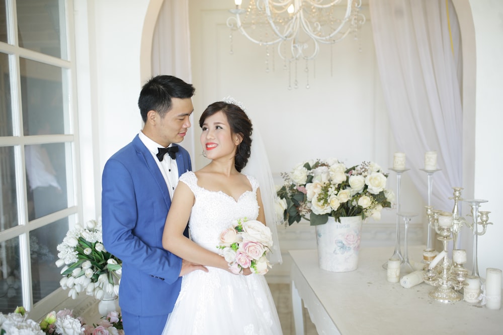 a bride and groom standing in front of a table