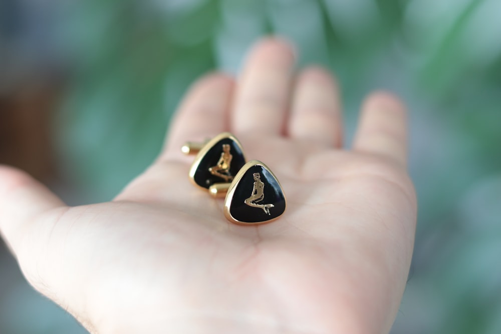 a person holding a pair of earrings in their hand