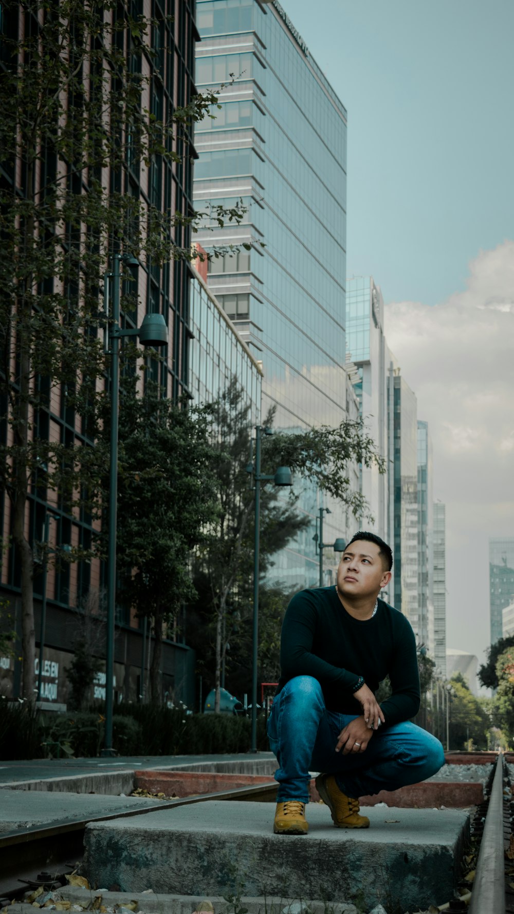 a man sitting on steps in front of tall buildings