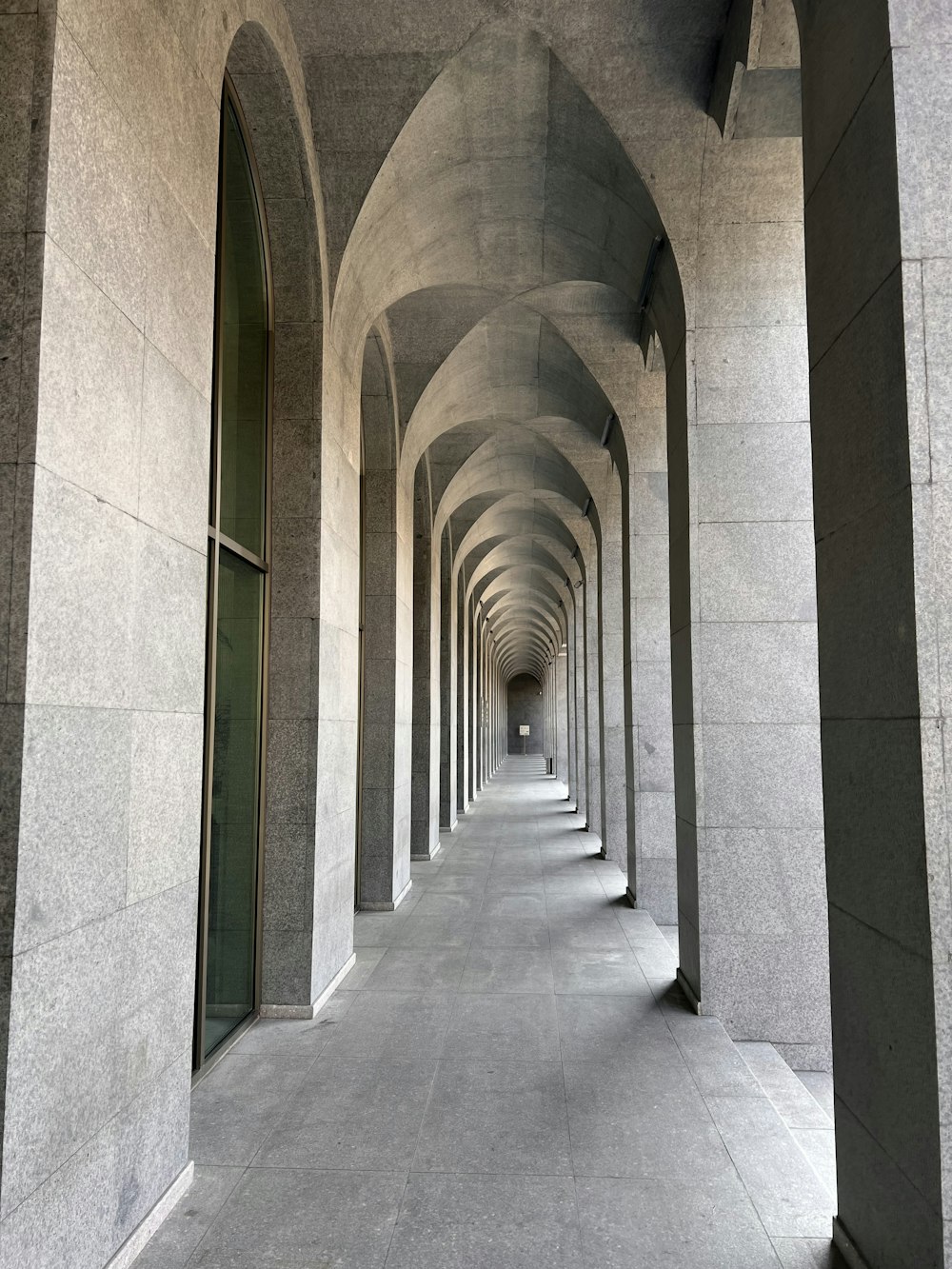 a long hallway with arches and a clock on the wall