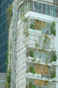 Installation team from Arjilli Enterprises fitting invisible grills on a high-rise apartment balcony