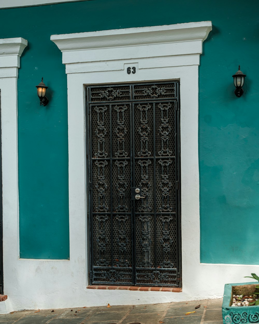 ein blau-weißes Gebäude mit schwarzer Tür