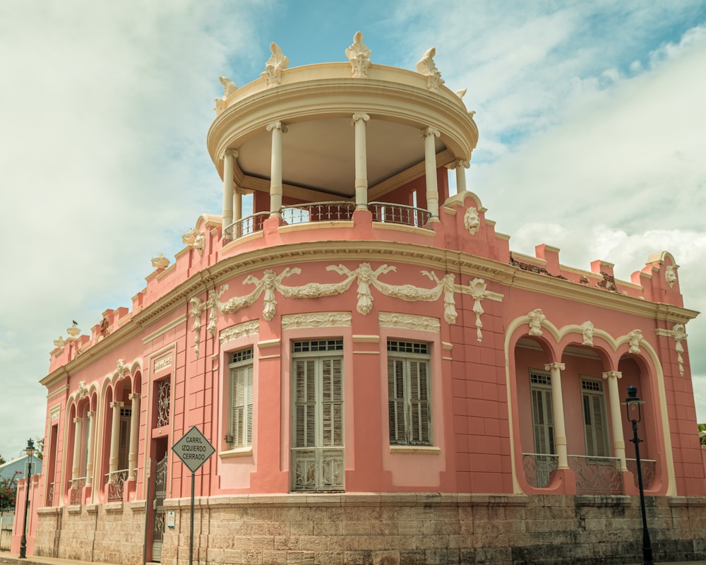 a pink building with a balcony and a balcony