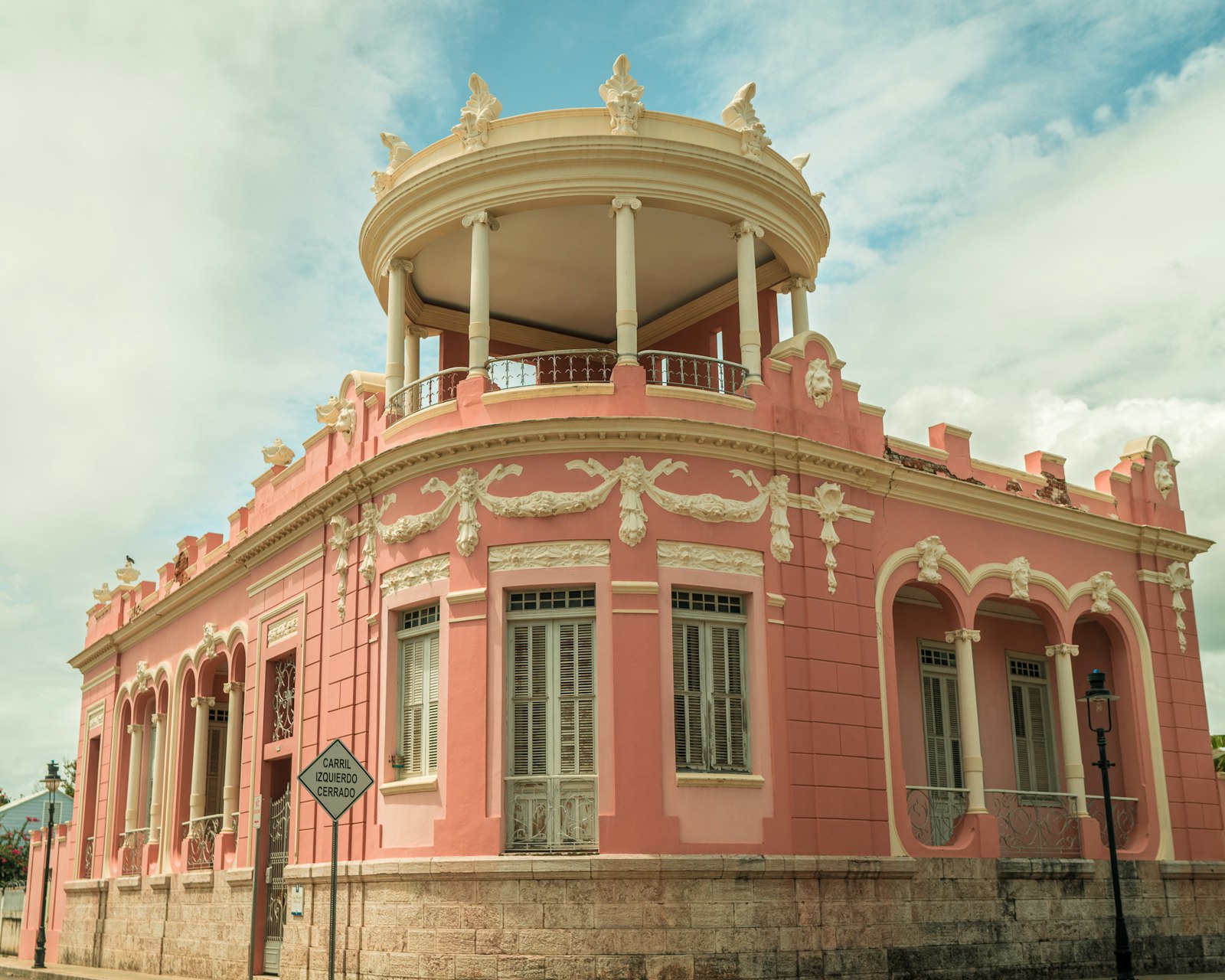 A pink neoclassical corner house with balconies in Ponce's historic district