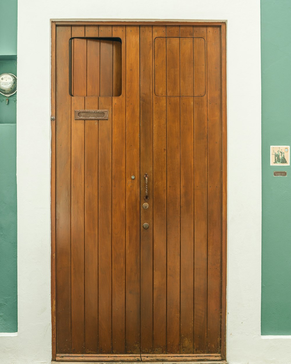 a wooden door with a clock on the side of it