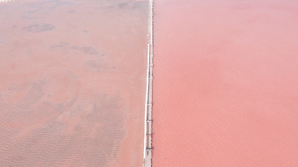 an aerial view of a beach with pink sand