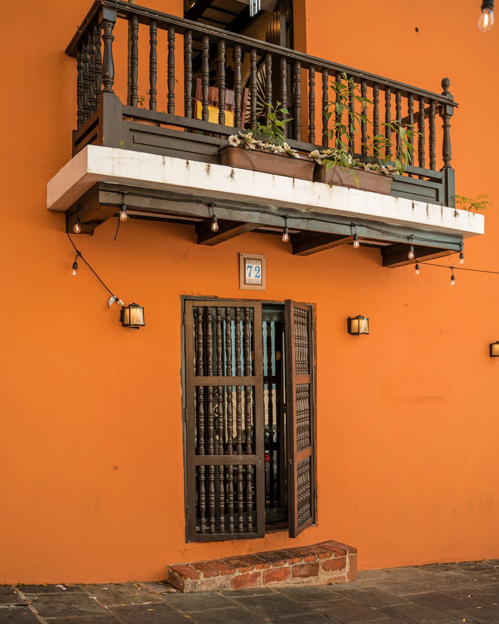 an orange building with a balcony and a window