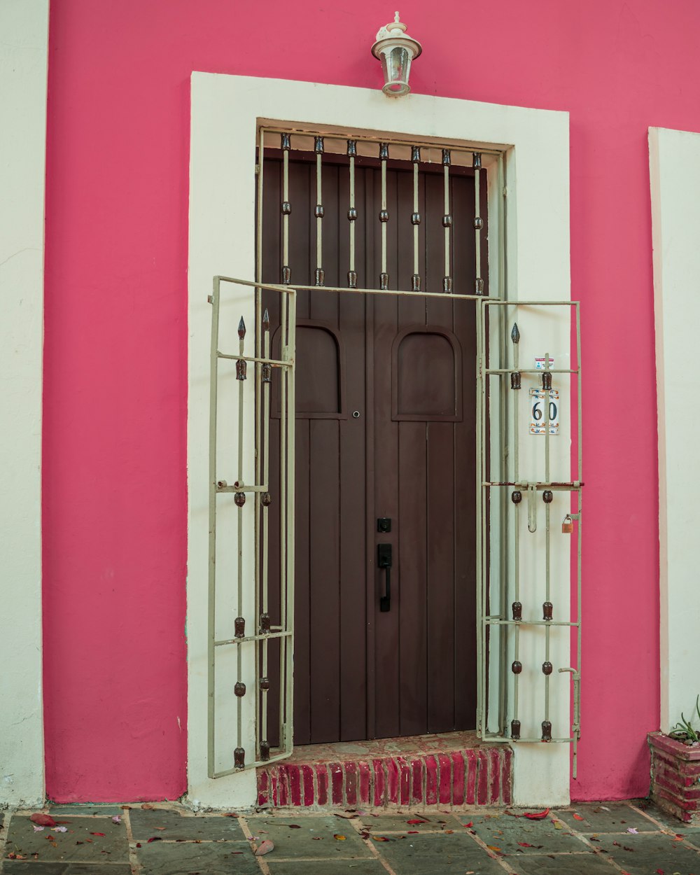 a pink building with a brown door and window