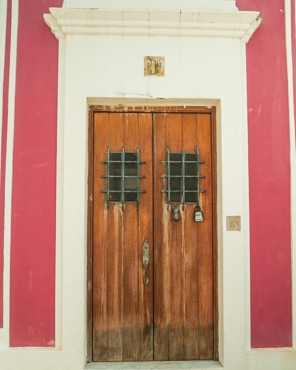 a red and white building with two wooden doors