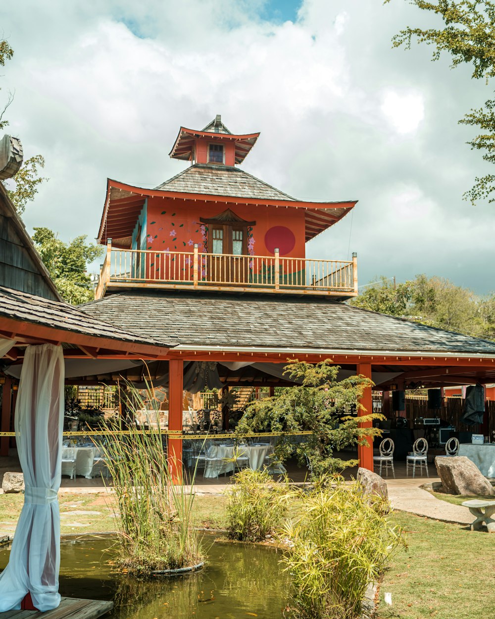 a gazebo with a gazebo on top of it next to a pond