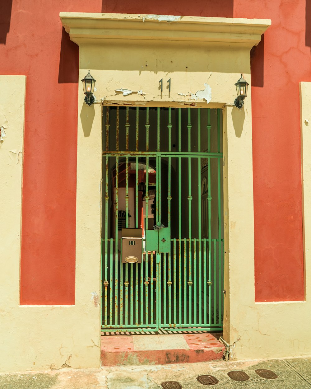 a red and yellow building with a green gate