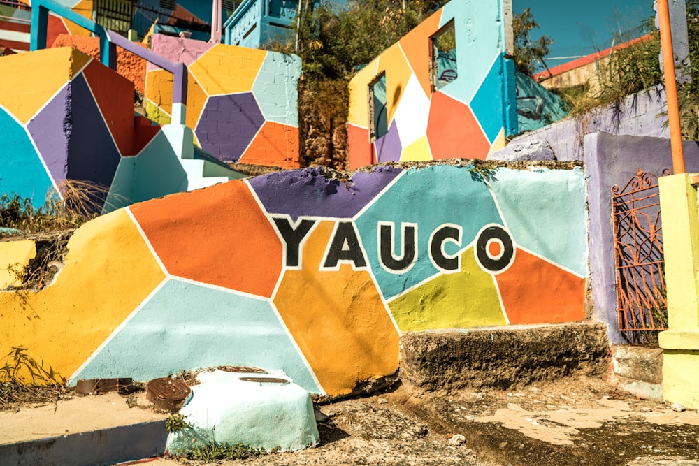 Una pared colorida con la palabra Yauco pintada en ella