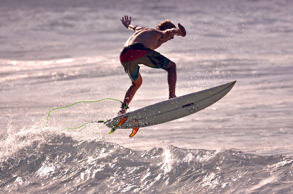 a man riding a surfboard on top of a wave