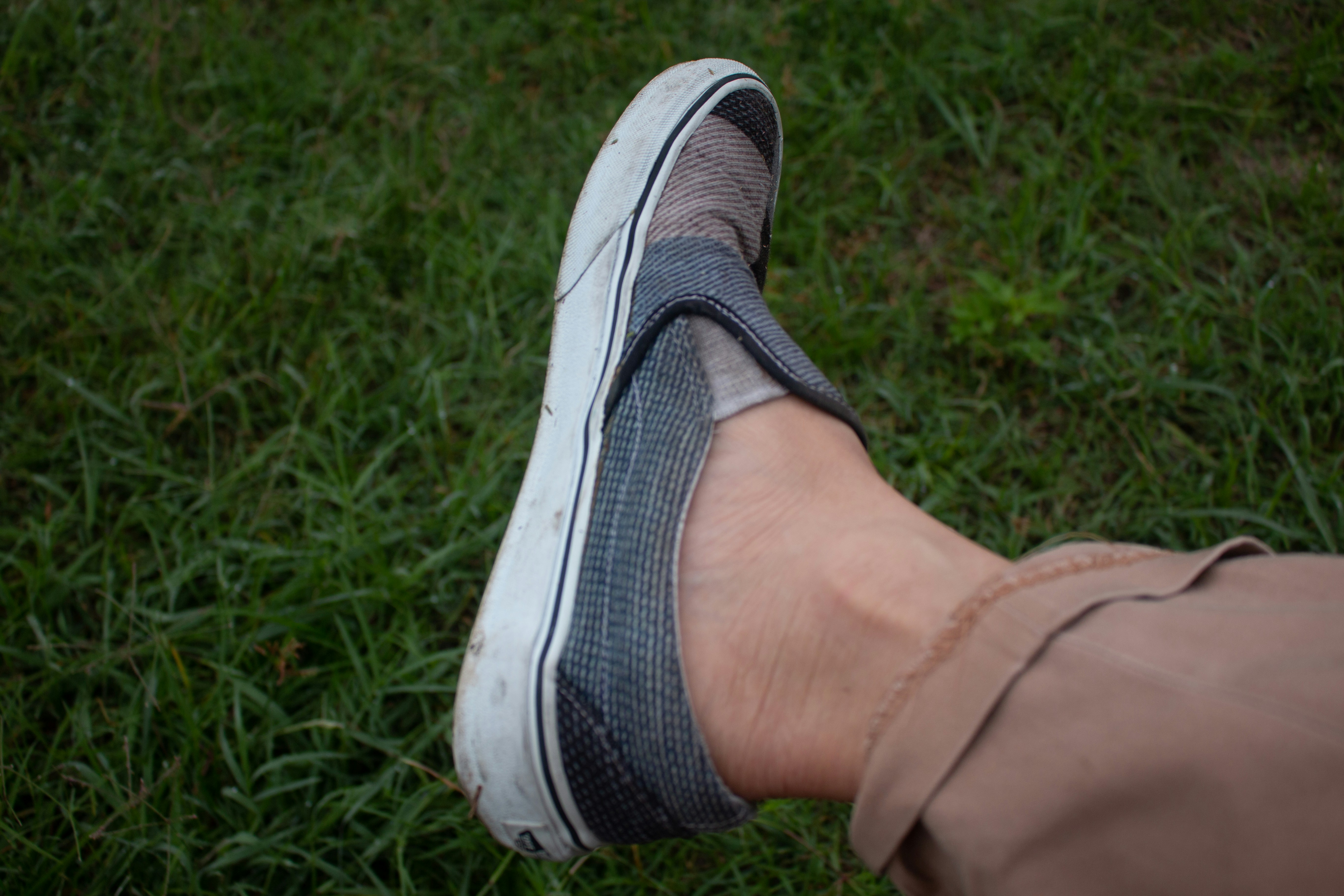a person's foot wearing a pair of sneakers