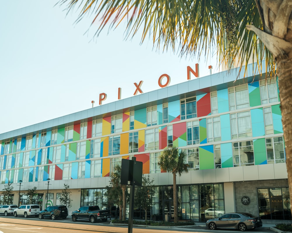 a large multicolored building with a palm tree in front of it