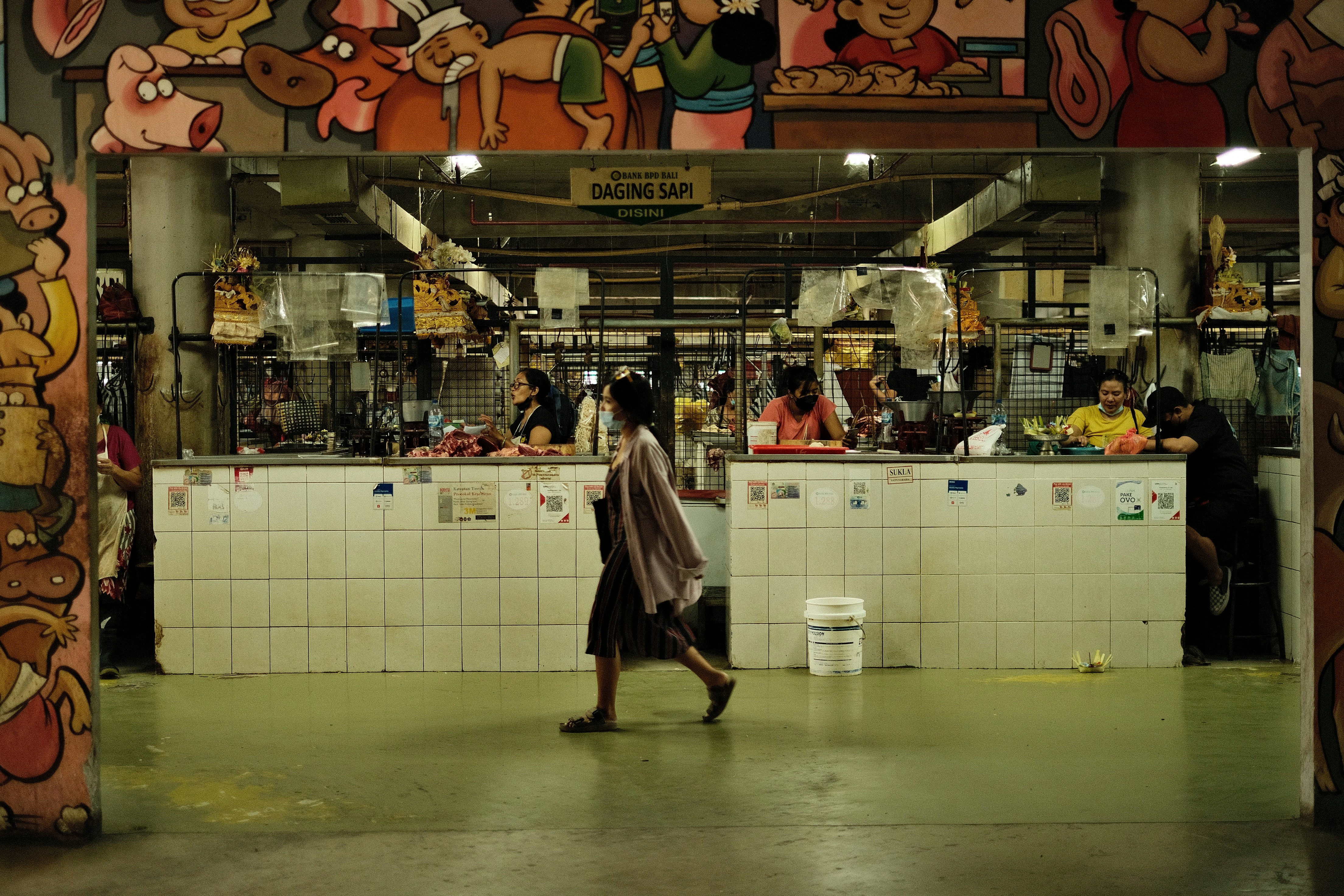 a woman walking through a kitchen filled with lots of food